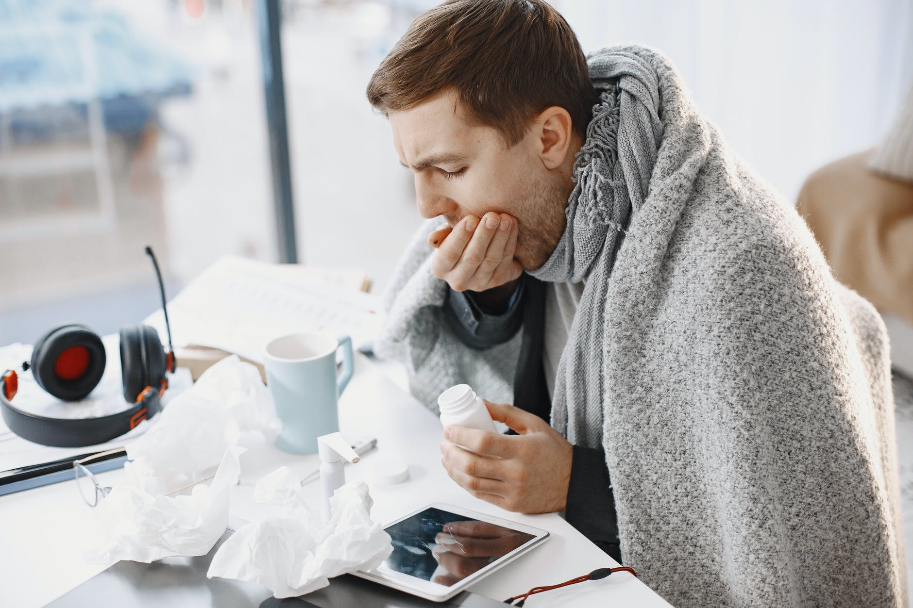 a sick man covering his mouth